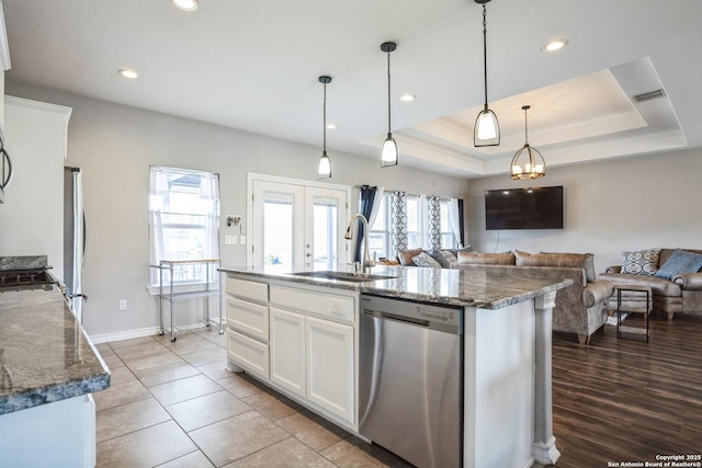 kitchen featuring a sink, white cabinets, appliances with stainless steel finishes, dark stone counters, and a tray ceiling