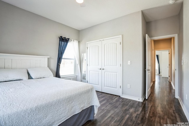 bedroom with dark wood-style floors, a closet, and baseboards