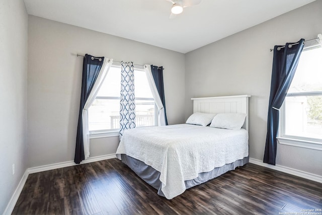 bedroom with dark wood-type flooring, multiple windows, and baseboards