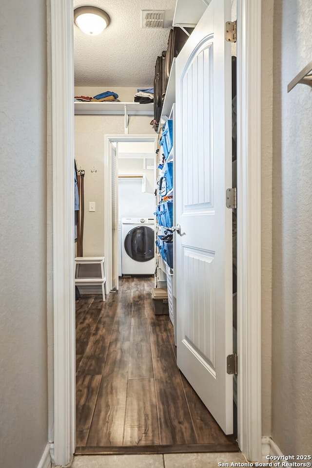 walk in closet featuring visible vents, washer / clothes dryer, and wood finished floors