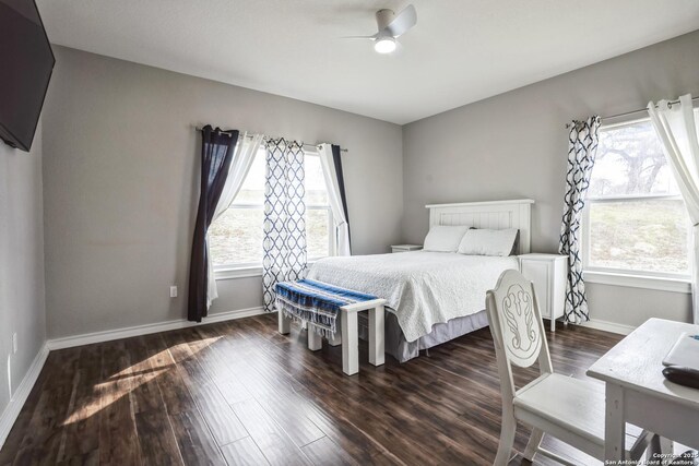 bedroom featuring a ceiling fan, dark wood-style flooring, multiple windows, and baseboards