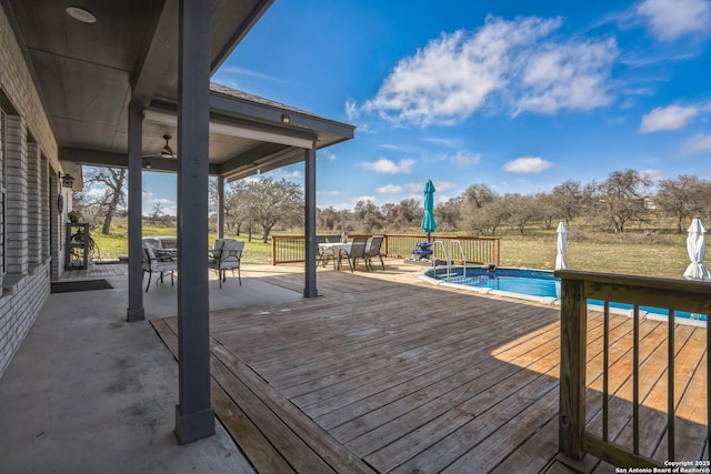 wooden deck with outdoor dining space and an outdoor pool