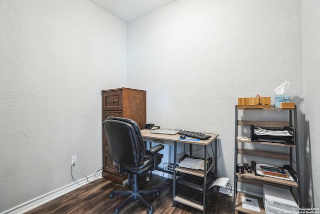 office area featuring baseboards, dark wood-type flooring, and a textured wall