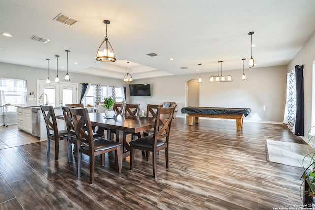 dining room with dark wood-type flooring, a raised ceiling, and visible vents