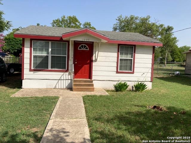 bungalow-style home with entry steps, a front yard, and fence