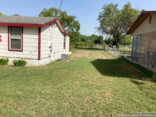 view of yard with a fenced backyard and central air condition unit