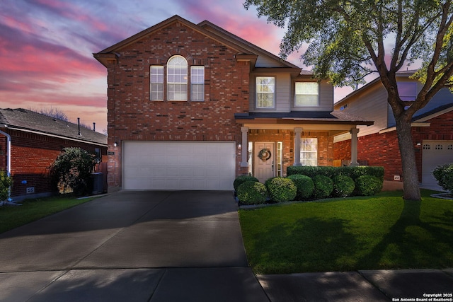 traditional-style home featuring brick siding, central AC unit, a garage, driveway, and a front lawn