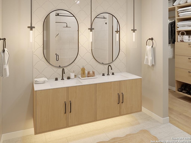 full bath featuring double vanity, a sink, and baseboards