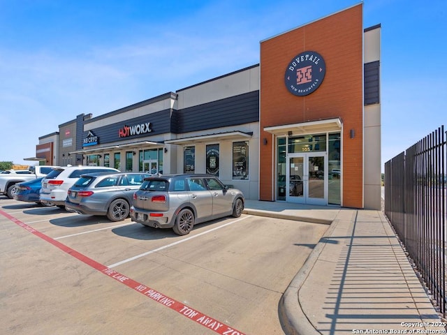 view of property with uncovered parking and fence