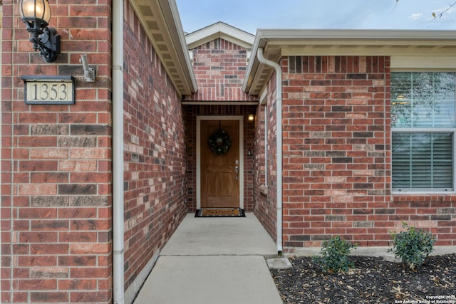 doorway to property featuring brick siding