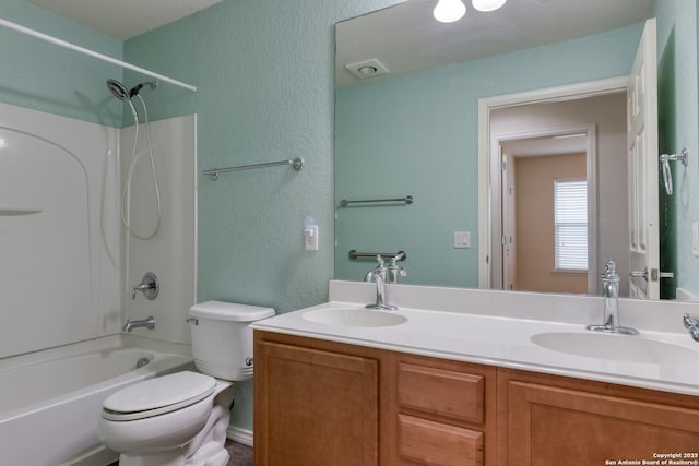 bathroom with a sink, toilet, double vanity, and shower / tub combination