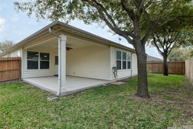 back of house featuring a ceiling fan, a patio, a yard, and a fenced backyard