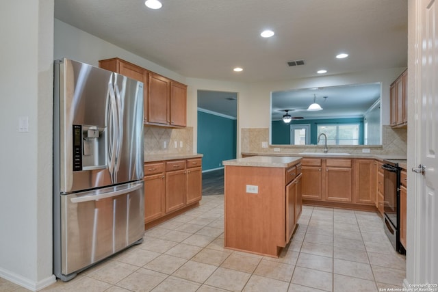 kitchen with visible vents, stainless steel fridge with ice dispenser, light countertops, black electric range, and a sink