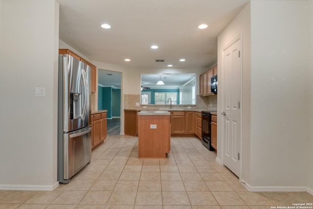 kitchen featuring backsplash, light countertops, light tile patterned floors, black appliances, and a sink