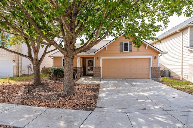 view of front facade featuring central air condition unit, driveway, an attached garage, and brick siding