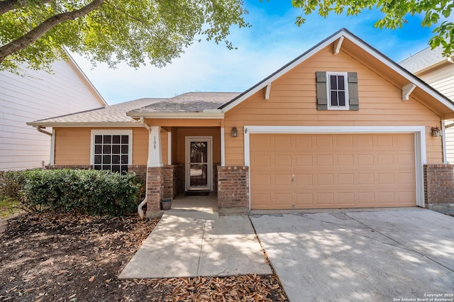 view of front of property featuring a garage, brick siding, and driveway