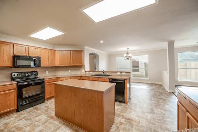 kitchen with tasteful backsplash, ornamental molding, a peninsula, black appliances, and a sink