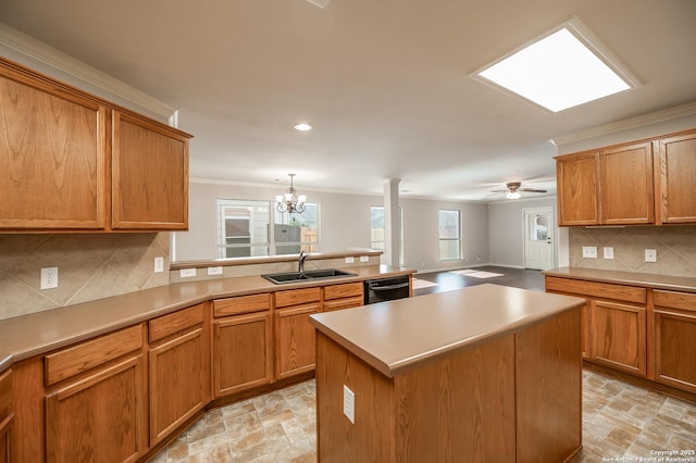 kitchen with backsplash, ornamental molding, a sink, dishwasher, and ceiling fan with notable chandelier