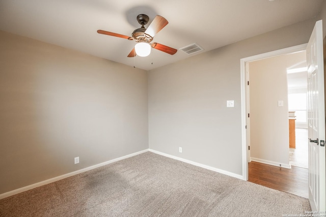 empty room with a ceiling fan, carpet, visible vents, and baseboards