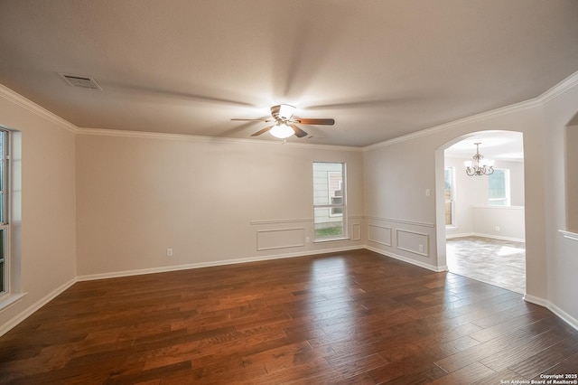 unfurnished room with a healthy amount of sunlight, visible vents, arched walkways, and dark wood-type flooring