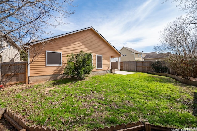 back of house featuring a fenced backyard, a yard, and a patio