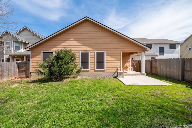 rear view of property featuring a yard, a fenced backyard, and a patio