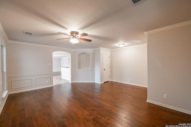 unfurnished room with arched walkways, dark wood finished floors, visible vents, ornamental molding, and ceiling fan