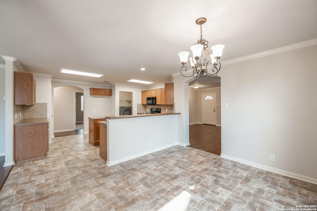 kitchen featuring arched walkways, ornamental molding, backsplash, and black microwave