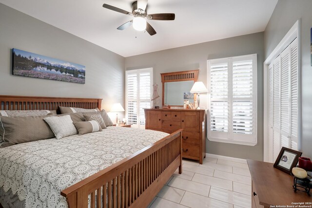 bedroom with light tile patterned floors, a ceiling fan, and baseboards