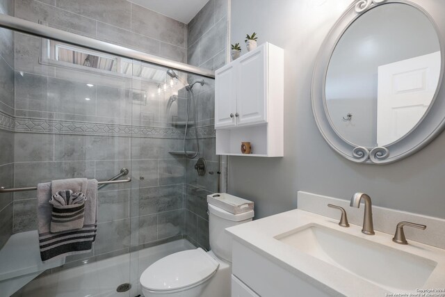 bathroom featuring a stall shower, vanity, and toilet