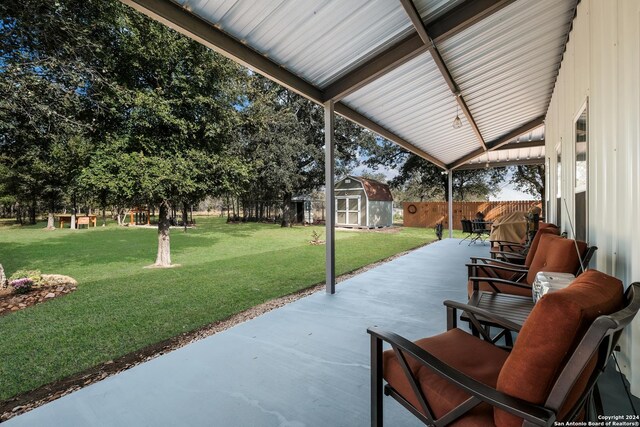 view of patio / terrace featuring a fenced backyard, a storage unit, and an outdoor structure