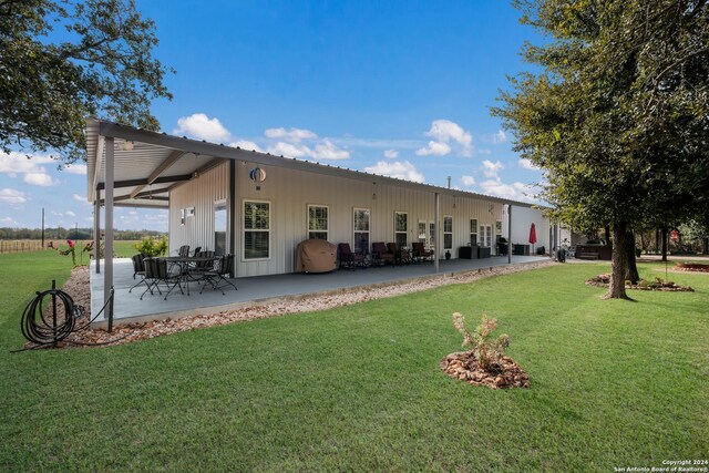 back of house with a yard and a patio