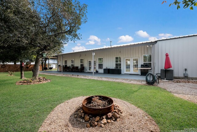 rear view of house featuring metal roof, a patio, french doors, and an outdoor fire pit