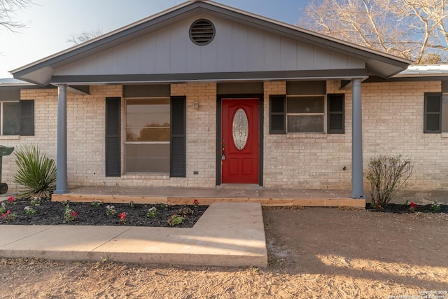 view of front of home featuring covered porch and brick siding