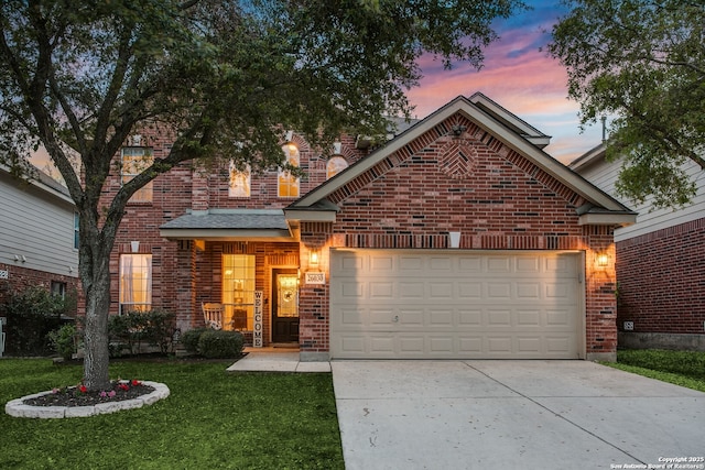 traditional-style house with a garage, driveway, a front yard, and brick siding