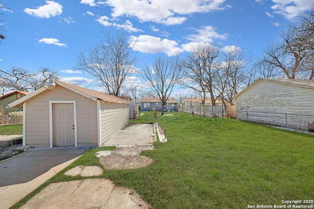 view of yard with a storage shed, fence, and an outdoor structure