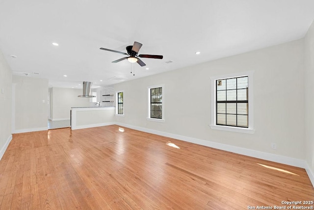 unfurnished living room with a ceiling fan, light wood-type flooring, baseboards, and recessed lighting