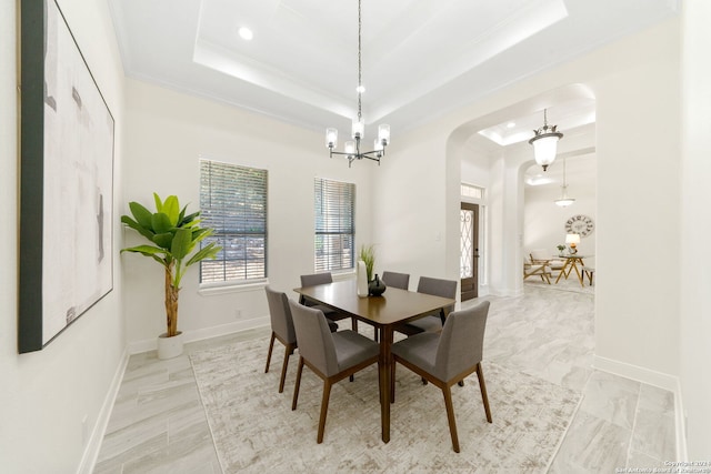 11217 Cave Crk, Helotes, TX 78023 - dining area with baseboards, arched walkways, a raised ceiling, crown molding, and a notable chandelier