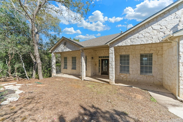 11217 Cave Crk, Helotes, TX 78023 - rear view of house with a shingled roof and stone siding