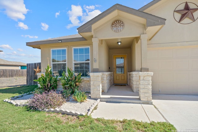 property entrance featuring a garage, stone siding, fence, and stucco siding