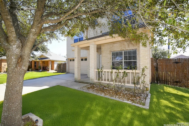 view of front of home featuring driveway, a garage, fence, and a front yard