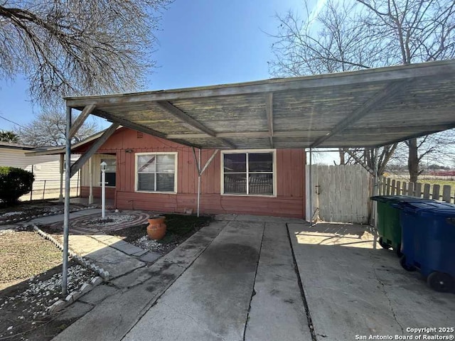 exterior space featuring a carport and fence