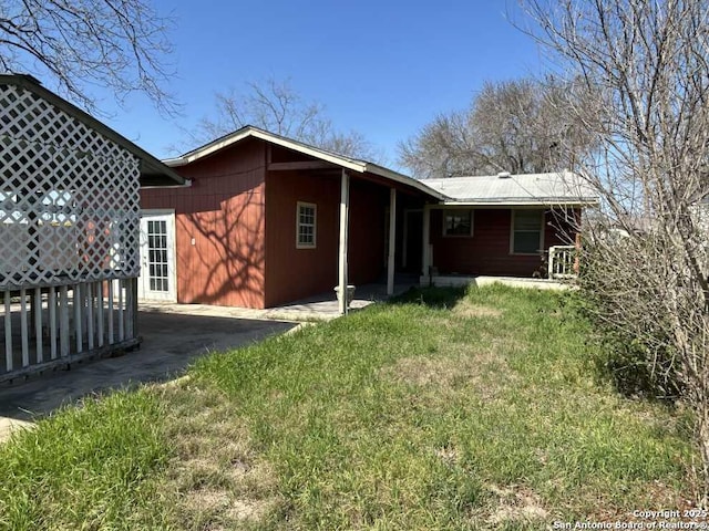 rear view of property featuring a yard