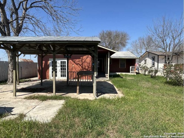 view of yard with fence and french doors