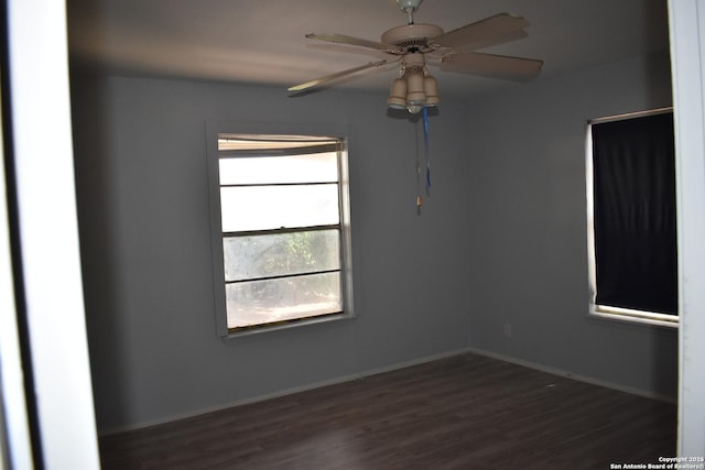 unfurnished room with dark wood-type flooring, baseboards, and a ceiling fan