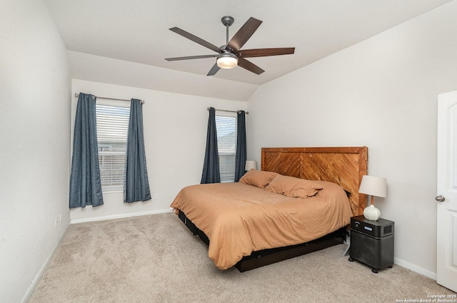 bedroom featuring lofted ceiling, baseboards, and carpet