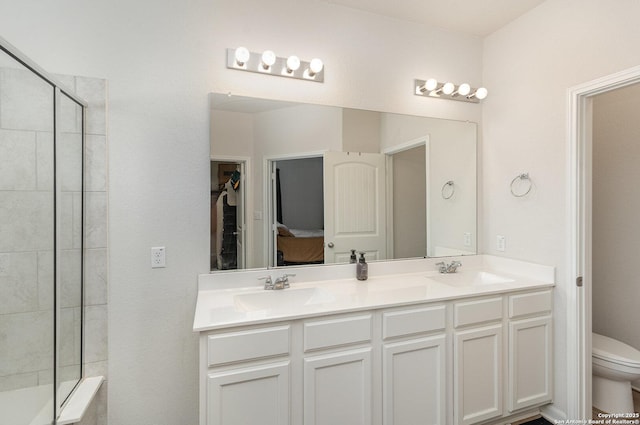 full bathroom with a tile shower, double vanity, a sink, and toilet