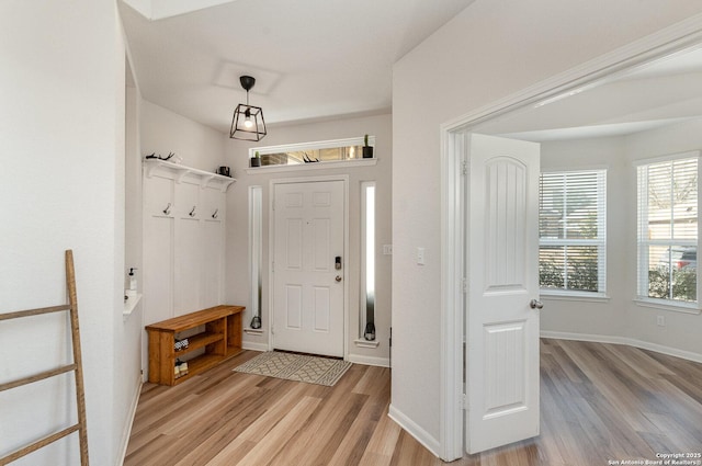 foyer entrance featuring baseboards and light wood-style floors