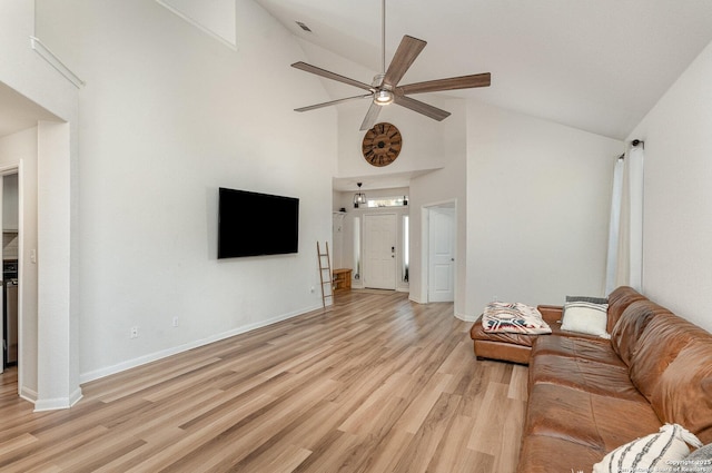 unfurnished living room with high vaulted ceiling, light wood-style floors, baseboards, and a ceiling fan