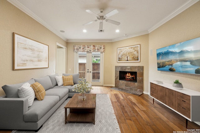37 Westerleigh, San Antonio, TX 78218 - living room featuring wood finished floors, crown molding, ceiling fan, a tiled fireplace, and recessed lighting